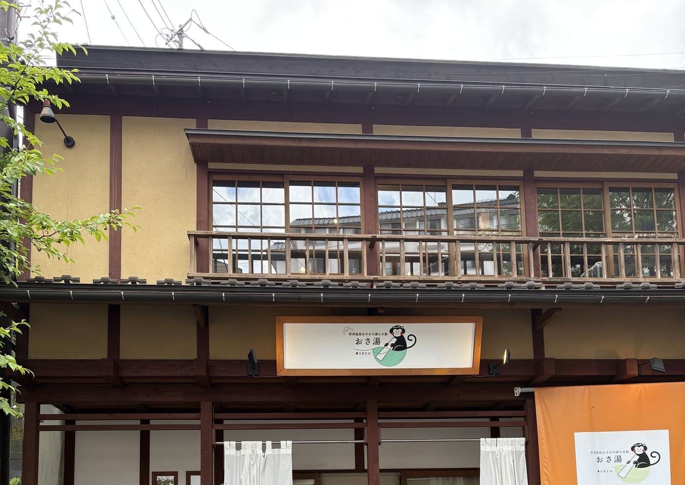 おさ湯の建物。湯もみをするお猿さんが描かれた看板が掲げられている(筆者撮影)